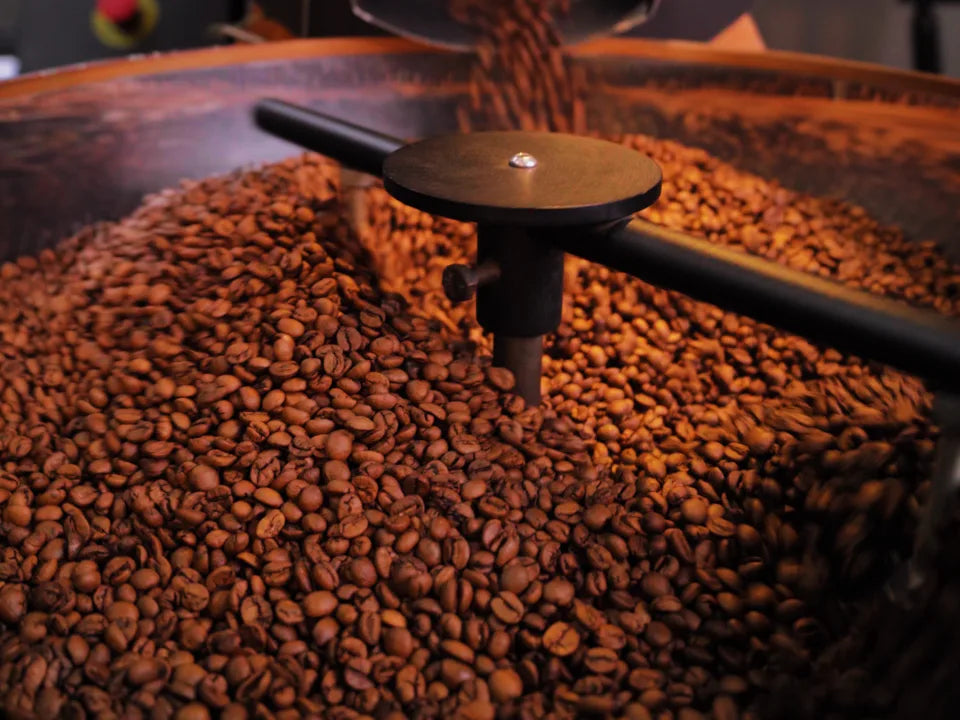 Torrador com grãos de café saindo